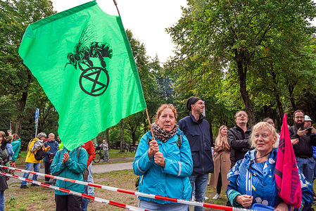Protesters hold flags during the non-violent sit-down demonstration. Today’s non-violent sit-down demo on the Utrechtsebaan, was the fifteenth-day of the A12 protest blockade in The Hague. The police arrested 552 activists on Saturday who were partially blocking the A12 in The Hague, 200 were arrested yesterday. Extinction Rebellion demonstrations have now blocked the main entrance road to the A12 for the fifteenth day in a row, demanding that the government stop supporting the fossil fuel industries. Police again used water cannon against the protesters. The 552 arrested demonstrators were taken by bus to the ADO football stadium and released without further action. The action group threatens to repeat these actions indefinably until their demands are met.