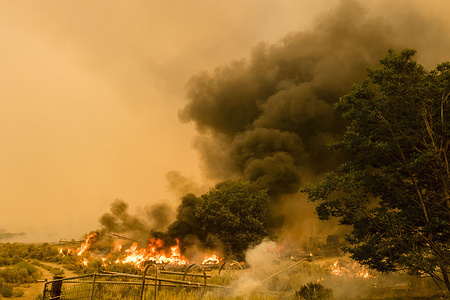 Farm equipment and tires burn in a field.
A spot fire from the Dixie Fire spreads to the highway 395. Cal Fire reports that the Dixie Fire has now grown over 600,000 acres. It remains 31 percent contained. The cause of the fire is still being investigated.