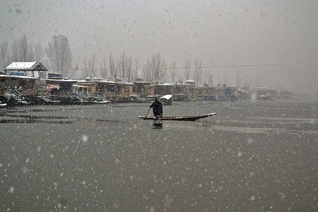 A man rows his boat across Dal lake during the seasons first snowfall in Srinagar, Indian administered Kashmir. Right at the advent of winter, Kashmir valley has received its first snowfall as cold wave like conditions gripped the Valley due to continuous downpour. All weather stations across the Valley Friday witnessed a drop of around 10 degrees Celsius from the normal day temperatures for this time of the year.