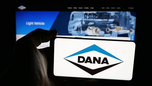 In this photo illustration, a mobile phone with the logo of US automotive company Dana Incorporated is seen on screen in front of web page.