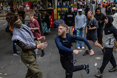 An anti-trans person punches a Trans Rights group protester in the face outside the State Library. In Melbourne, Trans Rights groups organized a counter-rally in response to an anti-trans event held at the state parliament. The demonstration, aimed at promoting equality and standing against discrimination, concluded with a march through the city center, drawing significant support from activists and allies across the community.