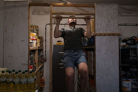 Anton, a volunteer driver for the shelter, is seen doing pull-ups inside the storage room, part of his daily routine to stay fit. As the Ukraine-Russia war enters its fourth year, the number of refugees has declined compared to the early stages of the conflict, leading to reduced demand for shelters near the Poland-Ukraine border. Hope Shelter in Przemyśl, founded in 2022, is one of the few remaining short-term refuges in the area. Operated by 10–15 unpaid volunteers working long hours, the shelter supports up to 50 refugees weekly despite dwindling resources. With funding and aid sharply reduced and access to new grants becoming increasingly difficult, the shelter faces the possibility of closure by September, even as the conflict shows no signs of ending.