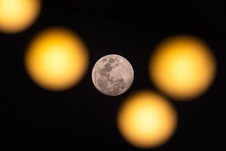 The full moon seen rising in the sky. The full moon in February is also known as "Snow Moon" that marks the second full moon of the year.