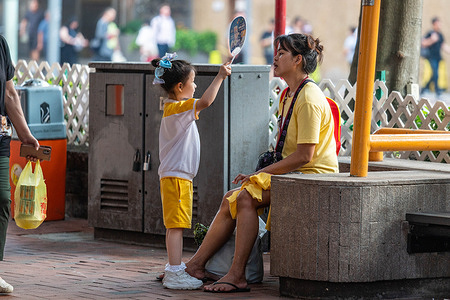 A little girl fans a woman in Quarry as an amber alert for extreme heat is issued. The Hong Kong Observatory recently launched a new weather alert system to warn residents about the health risks of extreme heat, advising them to seek shelter and drink more water.
