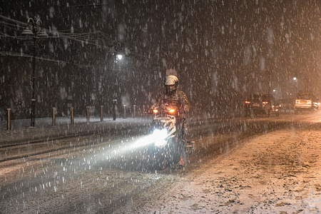 A man rides his scooter along the snow covered road during snowfall in Srinagar, the summer capital of Jammu and Kashmir.