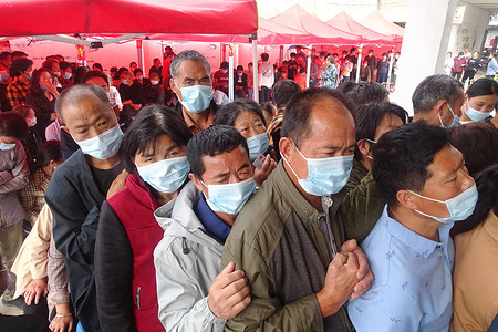 Rural residents wearing facemasks wait in line to receive the new coronavirus Vero Cell vaccine at a COVID-19 vaccination site in Anhui Province.