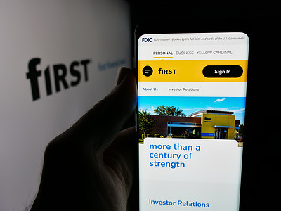In this photo illustration, a cellphone with the webpage of company First Financial Bancorp (Bankatfirst) is seen on screen in front of logo.