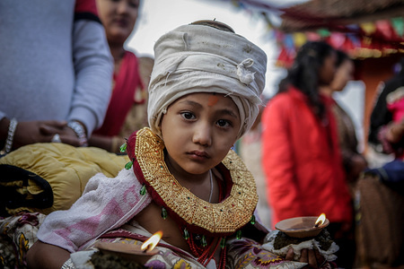 A child looks on with an oil lamp on his body as part of rituals at Branahini temple during tenth day of Dashain festival.
During the Dashain Festival, Nepalese Hindu devotees worship Durga, a mother goddess of power and prosperity, offering animal sacrifices, especially goats and buffalo. In general, the Dashain Hindu festival is a celebration of the victory of the gods over demons.