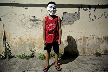 A child wears an anonymous character mask as a precaution against the spread of coronavirus in Jakarta.