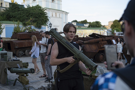 Residents of Kyiv take turns posing with captured Russian anti-tank weapons during an exhibition of Russian weaponry and equipment in Mykhailivska Square in Kyiv. Recovered Russian military equipment was put on display for residents of Kyiv to come and observe in Mykhailivska Square in Kyiv, Ukraine. The military hardware was collected from various battle fields in Ukraine by the National Museum of the Military History of Ukraine.
