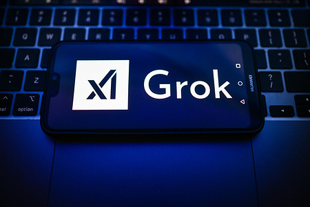 In this photo illustration, a Xai Grok logo is seen displayed on a smartphone on the top of a laptop.