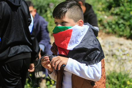 Masked protester with the flag of Palestine seen during the demonstration against Israeli settlements in the village of Beit Dajan near the West Bank city of Nablus.