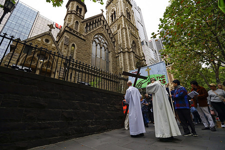 A priest leads worshippers during the Good Friday walk. Hundreds of people gathered on Good Friday to observe the Stations of the Cross in Melbourne, a solemn Christian devotion reflecting on Jesus Christ’s final hours. The procession began at St Francis’ Church on Lonsdale Street and continued through Melbourne’s central business district, stopping at stations outside various churches. Each of the 14 stations was marked with readings, prayers, and moments of reflection, commemorating Christ’s suffering and sacrifice. The tradition dates back to the 4th century and has been practiced in Australia since the 19th century, introduced by European settlers. The event brought together people of all faiths in a powerful display of mourning, reflection, and spiritual unity.