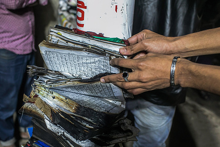 View of hands opening a burnt book around the scene of the devastating fire that broke out at Book shops at the market in the Nilkhet area of the capital on Tuesday afternoon.
Abdul Halim, assistant director of Fire Service and Civil Defense Headquarters, confirmed that the fire erupted in the book shops of Bakusha Hawkers Market around 7:47 pm. The Fire service declares fire under control around 8:45 pm after an hour-long effort of 10 firefighting units.