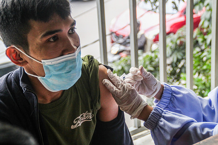 A health worker administers a Pfizer Covid-19 vaccine booster shot to a man. The health department aims to facilitate people who haven't got booster vaccinations as a condition of the Eid homebound (Exodus) trip 2022.