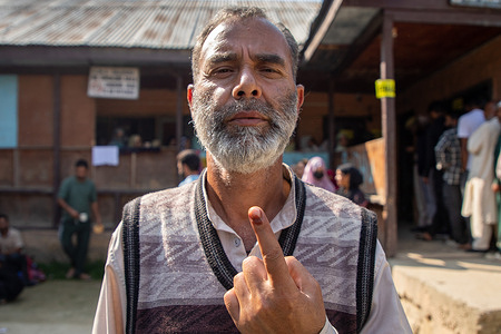 A Kashmiri voter shows his ink-marked finger after casts his ballot outside the polling station during the second phase of Jammu and Kashmir assembly elections in Budgam, south-west of Srinagar. These are the first local assembly elections in a decade and the first since New Delhi revoked the region's semi-autonomous status in 2019, placing it under direct rule. Nearly nine million people are registered to vote in the disputed region, which has traditionally been known for boycotts in protest against Indian rule.