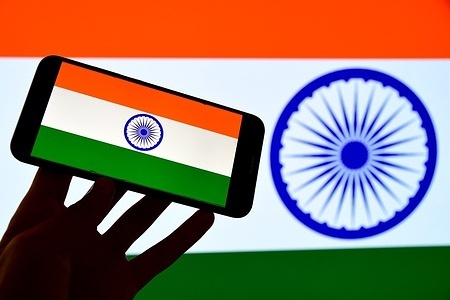 In this photo illustration, an Indian flag is displayed on a smartphone and in the background.