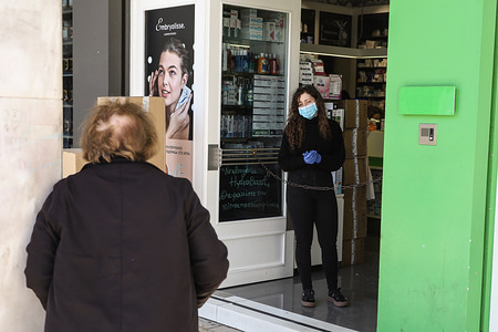 A worker at the entrance of a pharmacy controls the number of the costumers entering inside.
Coronavirus (SARS CoV 2) cases have almost doubled in Greece since March 13th. The total number of cases is around 352, while there have been 4 fatalities up to this day. The Greek government has taken extreme measures to slow down the epidemic. All schools, universities, venues (cinemas, theaters etc), bars, cafes, nightclubs, restaurants, gyms and public services are closed. Only supermarkets and pharmacies and take away chains are allowed to work.