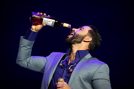 Brazilian singer Gusttavo Lima, best known for his Sertanejo musical style, drinks a wine while performing at the SuperBock Arena, in Porto.