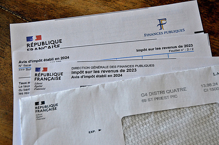 Income tax notice documents for the year 2023 seen displayed on a table in France.