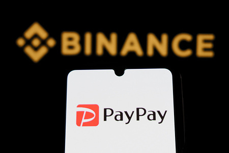 In this photo illustration, a Paypay logo is displayed on a smartphone with a Binance logo in the background.