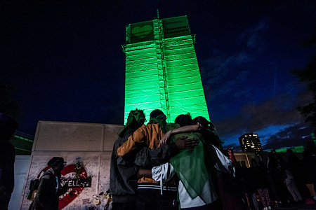 People seen embracing themselves at the foot of the Grenfell Tower.
On the first anniversary of the Grenfell Tower fire, which killed 72 people, the area around the tower has been filled with flowers, candles and messages to remember those who lost their lives.