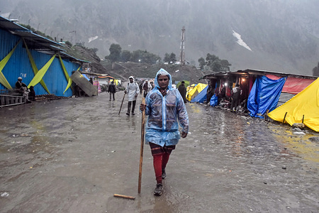 A Hindu woman devotee walks towards the sacred Amarnath Cave.
Thousands of pilgrims annually go to the remote Himalayan shrine of Amarnath at 3,888 meters (12,756 feet) above sea level to worship an icy stalagmite representing Shiva, the Hindu god of destruction.