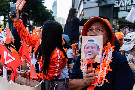 A supporter holds a portrait of Natthaphong Ruengpanyawut, prime ministerial candidate of the People's Party, during the election campaign rally of the People's Party at Siam Square One.