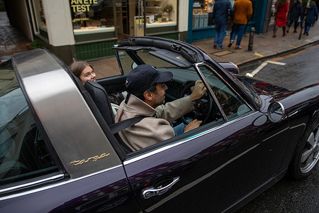 The occupants of a vintage 1970s Porsche 911 Targa take part in the Southside Christmas Hustle Meet and Supercar Parade. The Southside Hustle Car Meet happens on Wimbledon Common in Southwest London every first Sunday of the month, bringing together owners of classic, super, and unique cars. On Sunday December 7th at 1100, the Christmas meet included a supercar charity cruise through Wimbledon Village during the Christmas fair.