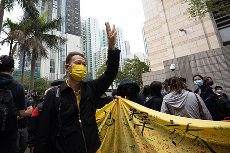 A Pro Democracy activist makes the three fingers salute in support of the arrested activists outside the West Kowloon Court.
47 pro-democracy activists charged with conspiracy to subvert state powers under the National Security Law attend their first court hearing as hundreds of their supporters comes to show their support outside the court building.