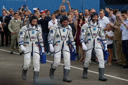 International Space Station (ISS) crew members Andrew Morgan of NASA, Alexander Skvortsov of the Russian space agency Roscosmos and Luca Parmitano of European Space Agency prepare to report to the Roscosmos officials before the departure to the launchpad at the Baikonur Cosmodrome, Kazakhstan