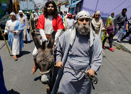 Residents of San Francisco Culhuacán participate in a procession to commemorate Palm Sunday and the Holy Week festivities in the capital. The residents performed a reenactment to commemorate Jesus' triumphal entry into Jerusalem, where he was received by the crowds with palms and olive branches as the Messiah, days before his crucifixion. Palm Sunday is celebrated on the Sunday before Easter.
