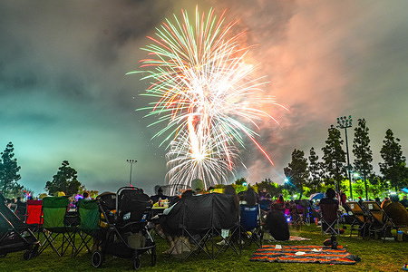 People watch the fireworks show in Mira Mesa neighborhood of San Diego. Families and friends gather at Hourglass Field Community Park in the Mira Mesa neighborhood of San Diego as fireworks light up the night sky during the community's Independence Day celebration on July 3, 2026, kicking off local festivities for America's 250th birthday. The annual event featured food vendors and a community picnic before a colorful fireworks display launch near Wangenheim Middle School, drawing hundreds of residents from across San Diego to celebrate the nation's milestone anniversary together.