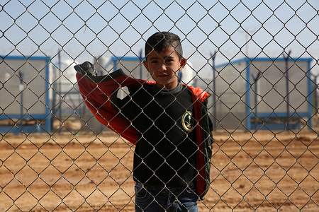 A child poses behind a fence in Zaatari refugee camp, the largest camp for Syrian refugees, which opened in 2012. It is gradually evolving into a permanent settlement.
There are currently over 700,000 Syrian refugees in Jordan escaping from the conflict in the home nation which started since 2011.