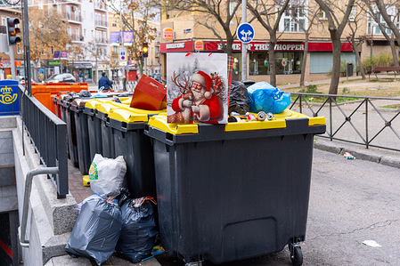 A Santa Claus bag is seen on top of trash cans along Madrid street.