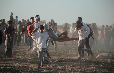 Palestinian medics are seen carrying an injured person during the clashes.
Palestinians clash with the Israeli forces during a protest calling for lifting the Israeli blockade on Gaza and demanding for the right to return to their homeland, at the Israel-Gaza border fence in the southern Gaza Strip.