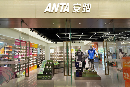 The front of an Anta sportswear store at Jiangnan Global Harbor showcases a beige signboard with white "ANTA" text, glass doors, and a variety of athletic shoes and clothing on display inside.