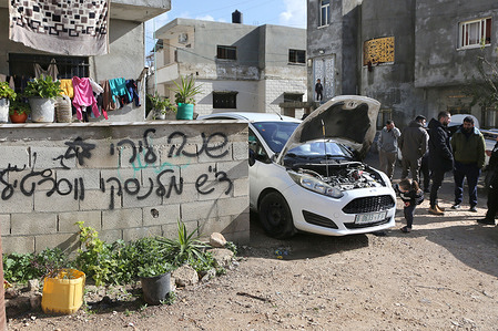Palestinians inspect the site where Jewish settlers set fire to six cars and spray-painted Hebrew graffiti on walls in the village of Bazari. Settlers also attacked Palestinian homes and set fire to a classroom at a Palestinian school in the northern West Bank. The Palestinian Red Crescent reported that a 45-year-old Palestinian man was injured during the settler attack and was taken to a hospital.