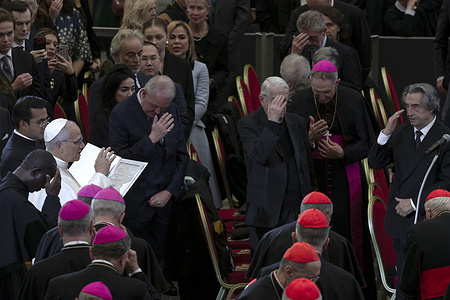 Pope Leo XVI gives his blessing at the end of a Christmas concert conducted by Maestro Riccardo Muti at the Paul VI Hall.