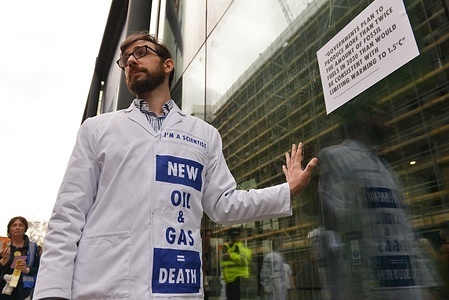 Extinction Rebellion scientist glued his hand on the glass at the UK Department for Business, Energy and Industrial Strategy during the demonstration. Extinction Rebellion scientists glued their hands to the glass at the UK Department for Business, Energy and Industrial Strategy, to demand the UK government to end investing on fossil fuels.