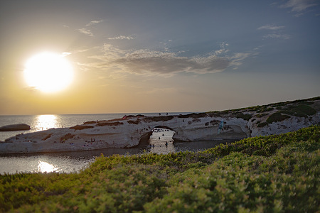 A view of the partial solar eclipse over the iconic S'Archittu natural monument in Cuglieri, Oristano on the western coast.