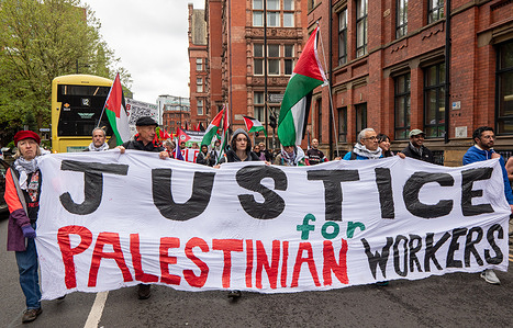 Protesters hold a Justice for Palestinian workers banner during the rally. International Workers’ Day (May Day) march in Manchester, UK. Demonstrators carrying union banners and placards marched through the city centre to the Mechanics’ Institute from Holt Town. Groups including pro-Palestinian activists and trade union members called for workers’ rights, social justice and solidarity.