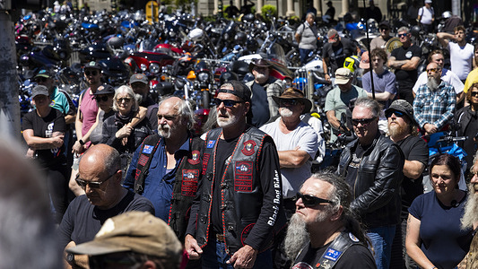 Rally attendees listen to speeches during the “Broken Roads” rally. Motorcycle riders and supporters gather for the “Broken Roads” rally, a protest organized by motorcycle clubs to highlight deteriorating road conditions and inadequate maintenance that is contributing to fatal crashes and vehicle damage. Demonstrators call on governments to address what they describe as “broken roads, broken promises,” demanding urgent action to create and maintain safer infrastructure to prevent further loss of life.
