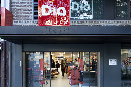 A pedestrian walks past the Spanish international hard-discount supermarket chain DIA in Spain.