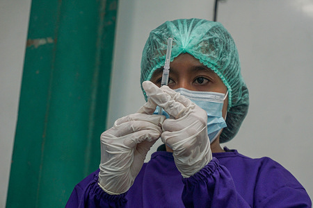 A health worker prepares an AstraZeneca vaccine.Mass vaccination of AstraZeneca Covid-19 vaccine held in Sanur region, as a stage of the Green Zone program in Bali. The Green Zone program which involves three regions in Bali; Ubud, Sanur, and Nusa Dua, are set to prepare an international tourism reopening plan.