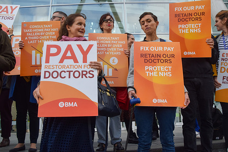 Junior and senior doctors stand with placards in support of fair pay at the British Medical Association (BMA) picket outside University College Hospital, as NHS (National Health Service) consultants and junior doctors stage their first ever joint strike.