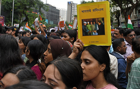 A demonstrator (R) holds a Indian Constitution book on her head during a protest in Mumbai. Youths supporting Cockroach Janata Party (CJP) held a protest against alleged paper leaks and irregularities in major national medical entrance examinations, seeking resignation of Union Education Minister Dharmendra Pradhan, demanding greater accountability and reforms in India's education system.