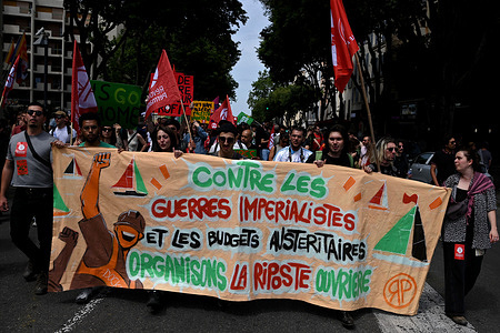 Protesters holding a banner and flags march through the streets of Marseille chanting slogans during the demonstration. Thousands of protesters took part in the annual May Day (Labor Day) marking the international day of the worker, in Marseille.