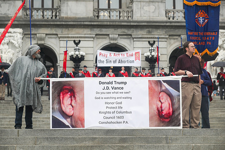 Men from the Knights of Columbus hold a banner on the steps of the Pennsylvania State Capitol during the Pennsylvania March for Life depicting Donald Trump's bloody ear. Hundreds of abortion opponents gathered at the Pennsylvania Capitol for the fourth annual Pennsylvania March for Life.