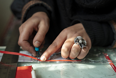 Sabreena Aaliya measures and cuts quilling paper to create quilling art at her home-based workplace. Sabreena Aaliya, a quilling artist has turned her passion into a thriving career blending art with cultural preservation. With a Master’s degree in Arabic, she creates intricate quilling pieces including flower panels, samovars, calligraphy and shikaras showcasing Kashmir’s rich heritage. Encouraged by her parents, especially her father’s structural support, Sabreena transformed her hobby into a commercial success, specializing in personalized designs. Beyond creating, she trains students in quilling, and inspiring others with her artistic entrepreneurship.